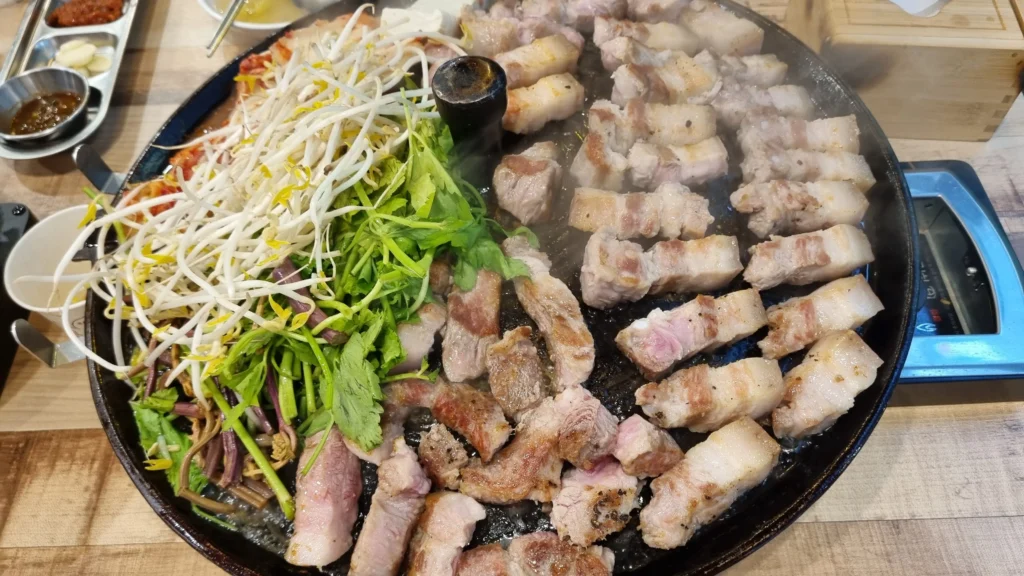Korean pork belly grilled on a cauldron lid
